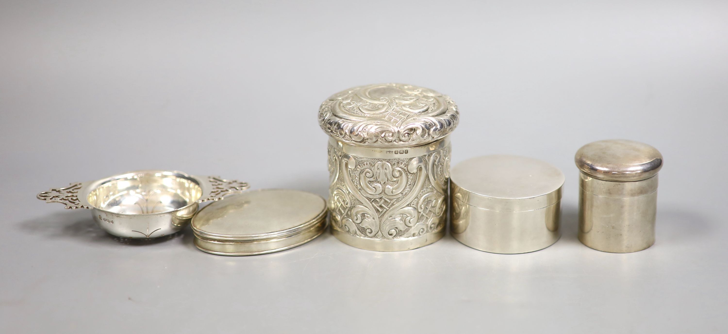 A Georgian silver snuff box of oval form, together with a small tea strainer and three other silver boxes, 10.5oz.